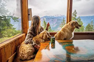 Gradeschooler Prints: A female and their dogs sitting at the table in a mountain cabin
