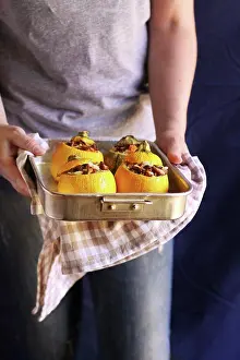 Round Prints: Female hands holding a pan with roasted stuffed zucchini