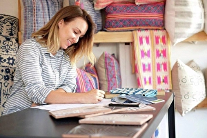 Business And Occupation Prints: Female interior designer drawing designs at desk in retail studio