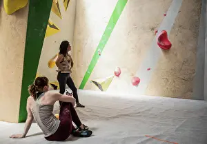 Multiracial Group Prints: Female rock climbers resting at climbing wall
