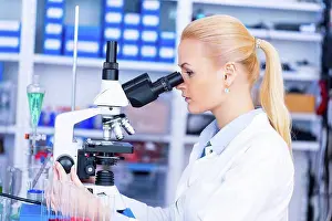 Technician Prints: Female scientist using microscope in the laboratory