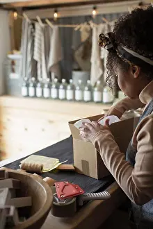 Prepare Prints: Female shop owner preparing package for shipping