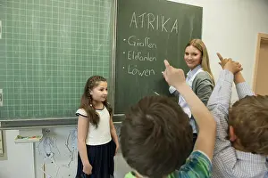 Multiracial Group Prints: Female teacher teaching students in classroom, Munich, Bavaria, Germany