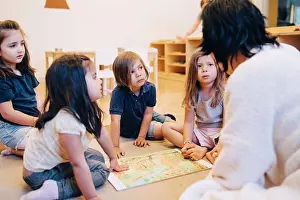 4 5 Years Prints: Female teacher telling story to students sitting in classroom at child care
