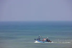 North Africa Prints: Fishing boat embarks into the Atlantic Ocean from the port at Tarfaya, in southern Morocco