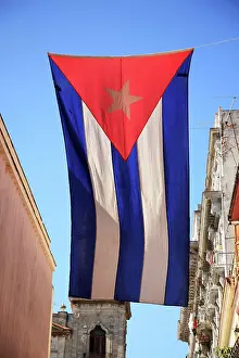Patriotic Prints: Flag of Cuba hanging between buildings in Havana Cuba