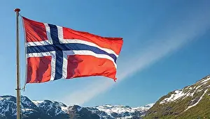 Symbolic Pictures Prints: The flag of Norway flutters in the wind, isolated against a blue sky