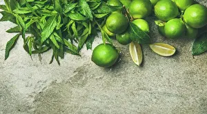 Back Ground Prints: Flatlay of freshly picked organic limes and mint for making cocktail or lemonade over grey concrete stone background