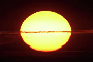 Manche Prints: France, Normandy. Closeup of the distorted sun shortly before sunset