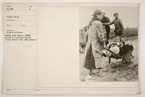 Wheelbarrow Prints: French girl using a wheelbarrow to transport her little sister away from danger during World War One