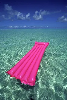 Clear Prints: French Polynesia, Bora Bora, Pink inflated raft on clear ocean water seen from Bora Bora lagoon