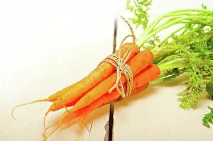 Naturalness Prints: Fresh baby carrots bunch tied with rope on a rustic table