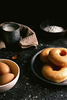 Flour Prints: Fresh doughnuts placed on rough table near various pastry ingredients and utensils in kitchen