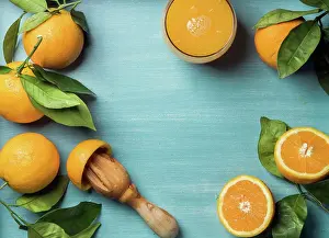 Breakfast Prints: Fresh orange juice in glass and oranges with leaves on wooden turquoise blue painted background