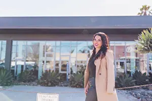 Mixed Prints: Friendly business woman walking on the street wearing a tan coat