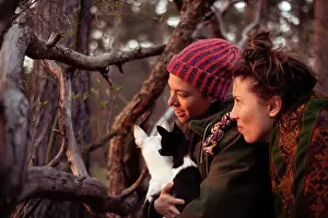 Brandenburg Prints: friends look through branches at sun set with small chihuahua in arms