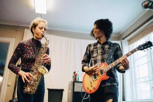 Talent Prints: Friends playing saxophone and guitar while practicing at recording studio