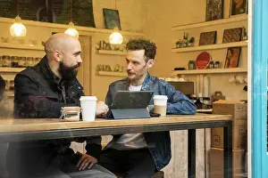 Looking Through Prints: Friends sitting in window of cafe with tablet