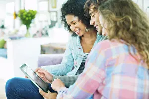 Worldwide Web Prints: Friends using tablet computer on sofa