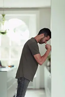 Separation Prints: Frustrated man with clenched fists leaning against wall