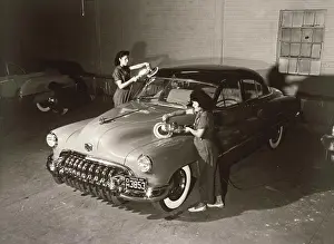 Manual Worker Prints: Garage mechanics polishing a car in a garage, 1950