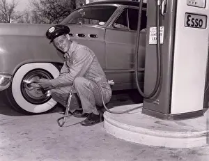 Crouch Prints: Gas station attendant checking the air pressure in a tire