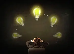 Innovation Prints: Geschäftsmann sitzt mit Lichtböcken über seinem Kopf Young businessman sitting in office chair in front of a balckboard