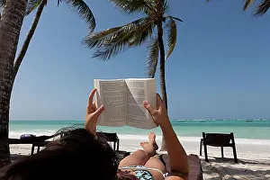 Relish Prints: Girl, 16 years, reading a book on the beach under palm trees