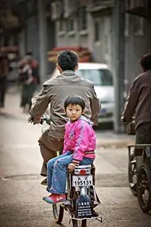 Out Door Prints: Girl on back of bicycle, looking at the camera