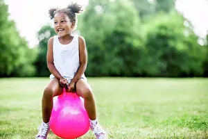 Focus On Foreground Prints: Girl bouncing on inflatable hopper