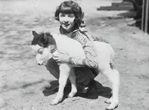 Adolescence Prints: Girl embracing young goat or donkey