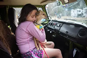 Hugging Prints: A girl hugs a chihuahua dog in VW camper van during roadtrip