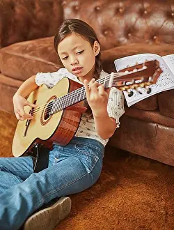 Vocal Prints: Girl learning how play guitar home