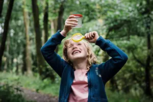 Hike Prints: girl looking through a magnifying glass at bugs in the forest