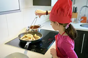 Prepare Prints: girl makes fritters in the frying pan at home