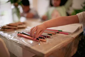 Authentic Prints: Girl reaching for colored pencil on table