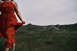 Elder Prints: A girl in a red dress running on the field, mountains