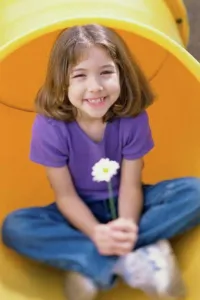 One Child Only Prints: Girl sitting in a pipe and holding a daisy