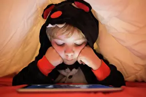 Tablet Prints: Girl using tablet under blanket