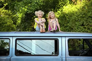 On Top Prints: two girls sitting on roof of vintage car laughing and smiling