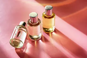 Sun Light Prints: Glass bottle cosmetics with oil for beauty or skin care on pink background