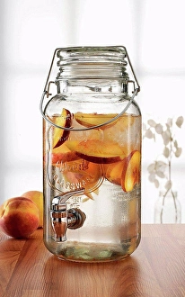 Glass Material Prints: Glass jar with tap dispenser containing fresh peach drink