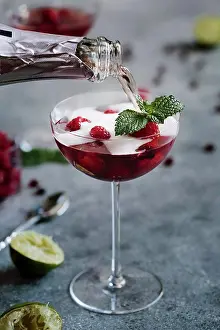 Rose Prints: A glass of Raspberry and Pomegranate Champagne Cocktail is being topped of with champagne
