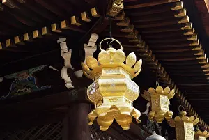 Golden japanese lanterns hanging from a temple roof, kyoto, japan