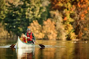 50 To 55 Years Prints: Grandfather canoeing on river with grandson