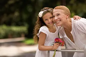 Handicapped Prints: Grandmother and her granddaughter laugh together holding a bunch of flowers