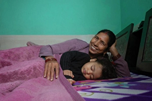 Little Girl Prints: Grandmother and her little granddaughter sleeping together in bed. India