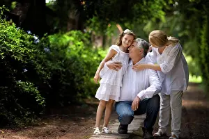 Baby Boomer Prints: Grandparents stand with their granddaughter on a quiet country road