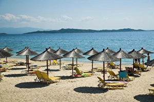 Small Group Of People Prints: Greece, Halkidiki, Beach umbrellas and chairs on tourist beach; Ouranoupoli