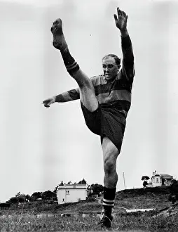 Community Prints: In the grey light of dawn Bob Scott limbers up his kicking leg in preparation for the approaching 1948 Rugby season